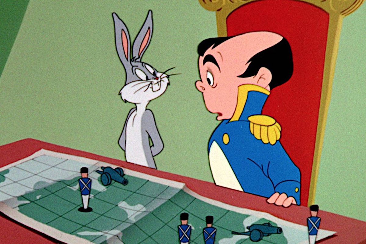 Bugs Bunny stands next to Napoleon as they look at a strategy map featuring various model soldiers and cannons in the 1956 short “Napoleon Bunny-Part”