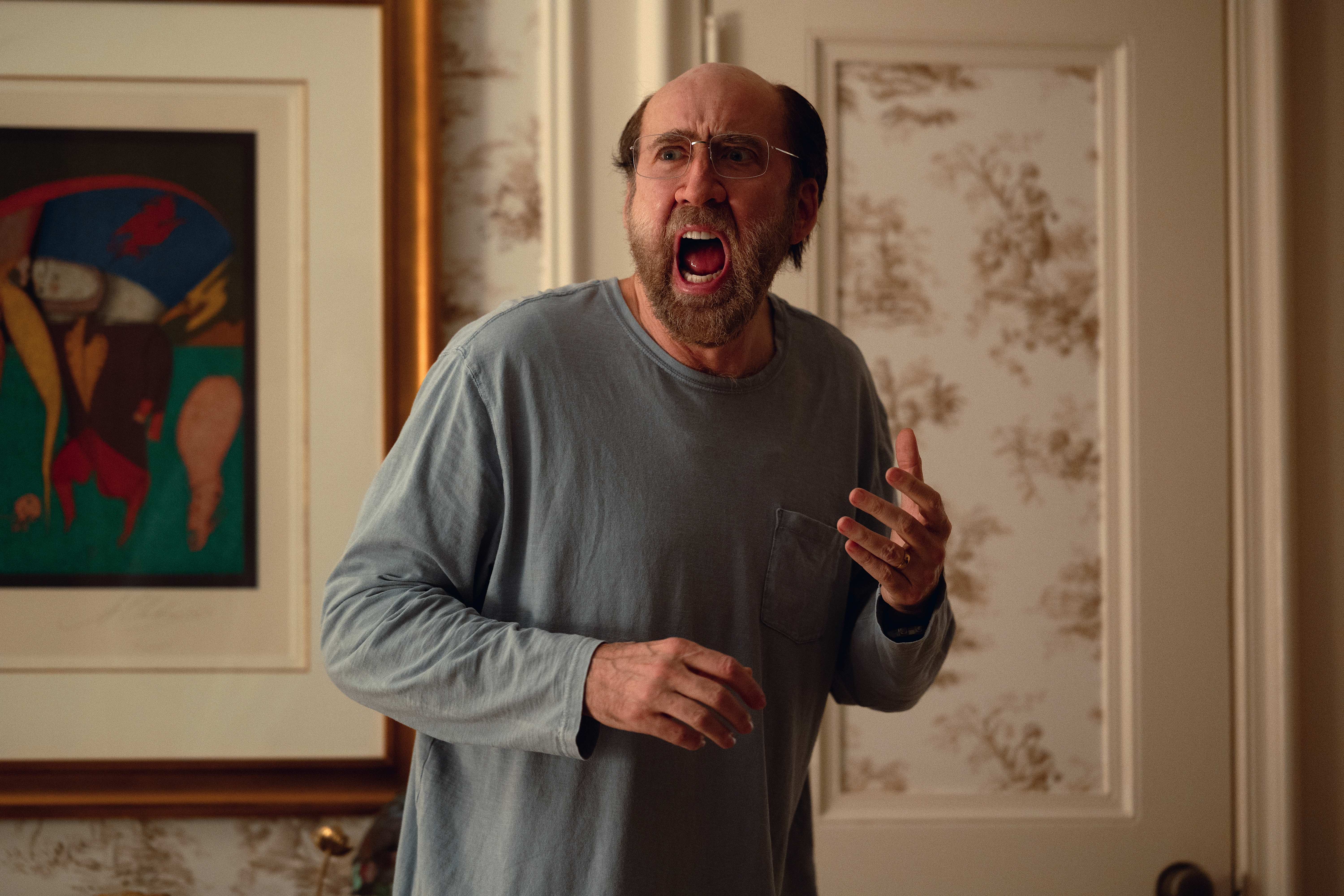 Balding, middle-aged professor Paul Matthews (Nicolas Cage) stands in his living room screaming in A24’s Dream Scenario