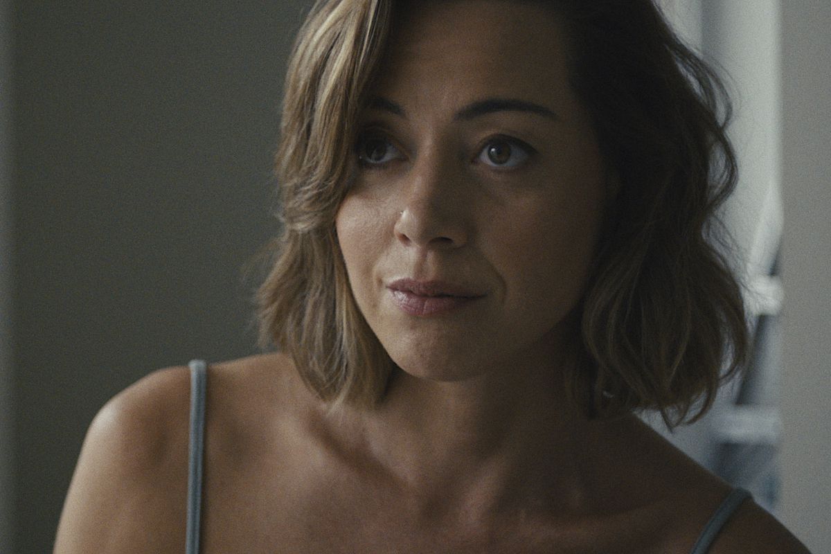 Aubrey Plaza stares defiantly past the camera with a slight smirk on her face in Emily the Criminal